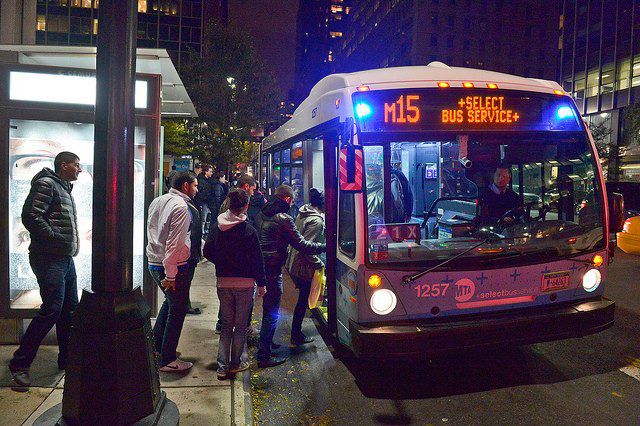 A bus picks up riders on Tuesday evening